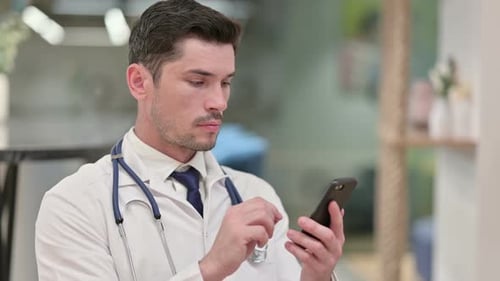 Doctor in White Coat Using Cell Phone