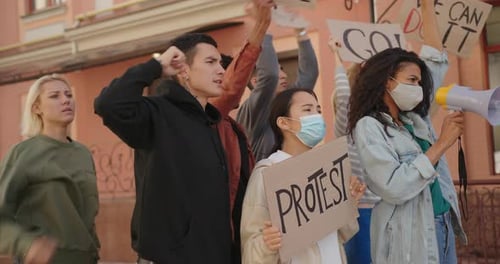 Diverse Group Protests With Signs and Megaphone