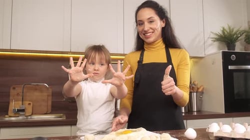 Cute Little Daughter are Playing and Smiling While Baking in Kitchen at Home