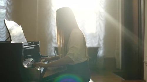 Woman Playing Piano in Sunlight Filled Room