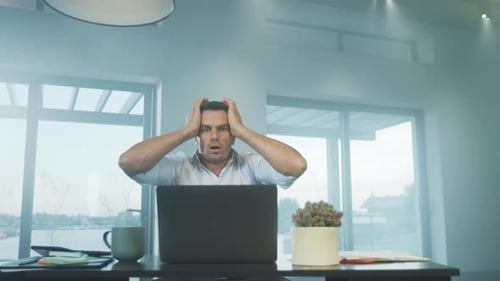 Frustrated Man Working on Laptop at Home