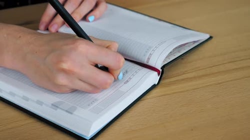 Close up businesswoman works at home office during isolation pandemic, writes information notebook