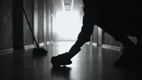 Silhouette of Unrecognizable Janitor Cleaning Floor