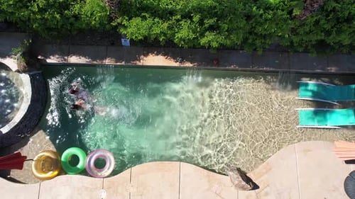 Aerial View of Children Swimming in Backyard Pool