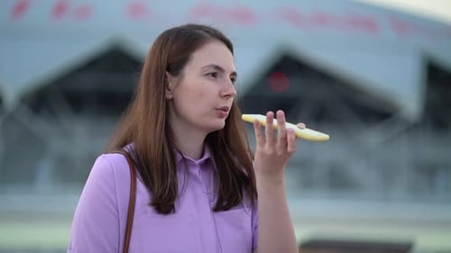 Young Woman Using Smartphone for Voice Message