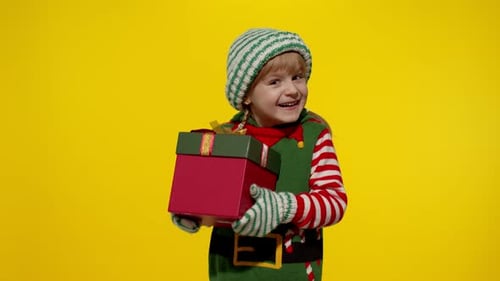 Happy Girl Holding Christmas Present in Elf Costume