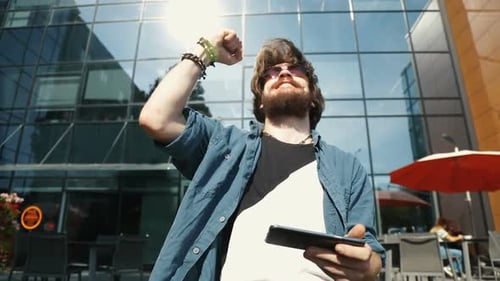 Young Adult Celebrates Smartphone Victory Outdoors