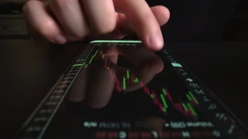 Businessman reading stock market chart on mobile phone, trading online.