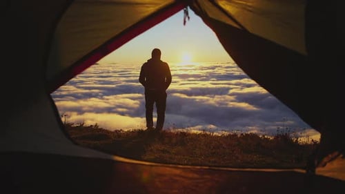 Person in Tent Overlooking Cloudscape at Sunrise