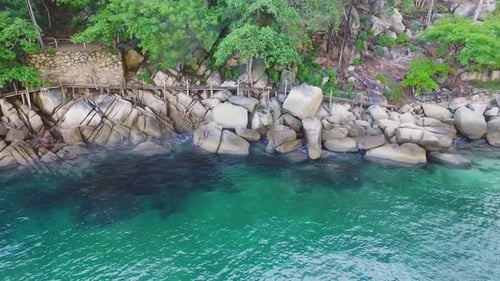 Aerial View of Rocky Tropical Coastline with Azure Ocean