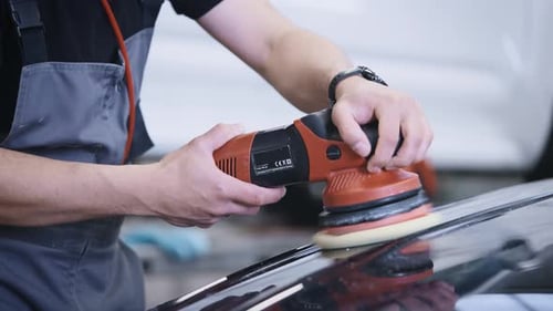 Adult Polishing Black Car with Electric Buffer