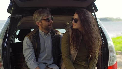 Man and Woman Talking in Hatchback by Lake