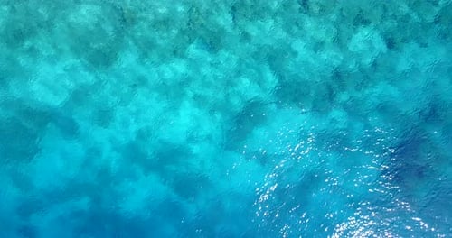 Wide aerial tourism shot of a sandy white paradise beach and aqua blue water background in high reso