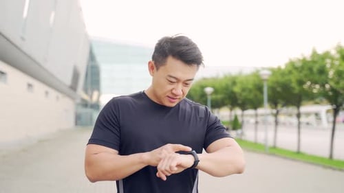 Man Using Smart Watch Outside Office Building