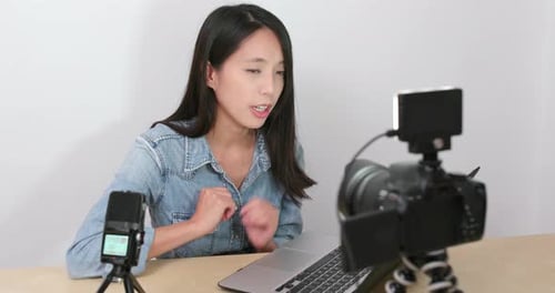 Woman Recording Vlog with Camera and Laptop