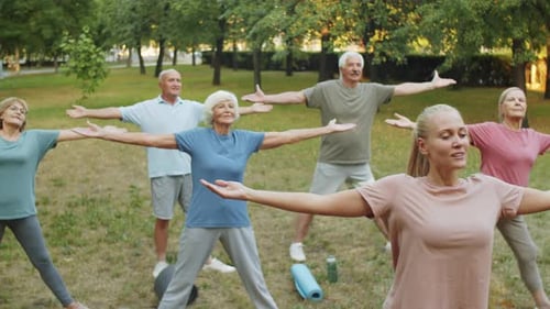 Seniors Exercising with a Trainer in the Park