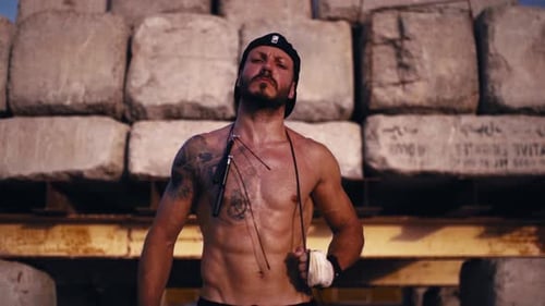 Shirtless Man with Jump Rope Poses Outdoors