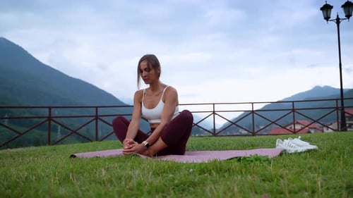 Woman Stretching on Yoga Mat Outdoors