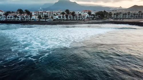 beautiful slow motion wave on the yellow sand beach in tenerife while a long oceanic foam