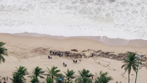 Freiwillige Frauen und Männer reinigen den Strand nach einer tropischen Depression
