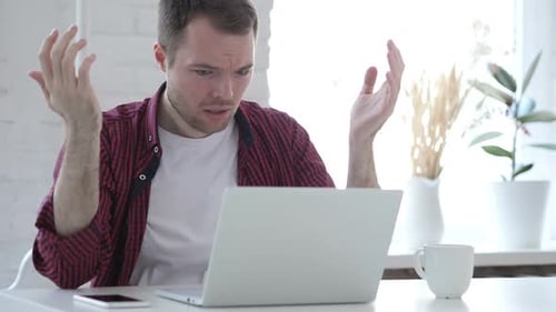 Frustrated Young Adult Working on Laptop