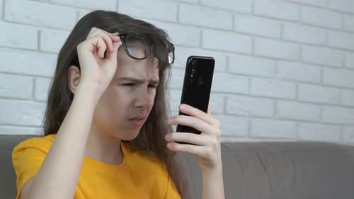 Girl Using Smartphone Wearing Glasses Indoors