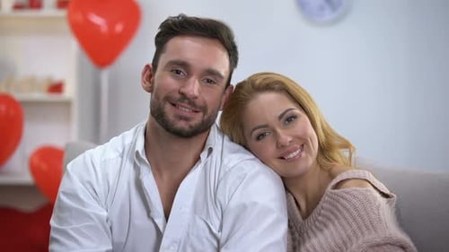 Smiling Couple Holding Red Paper Heart