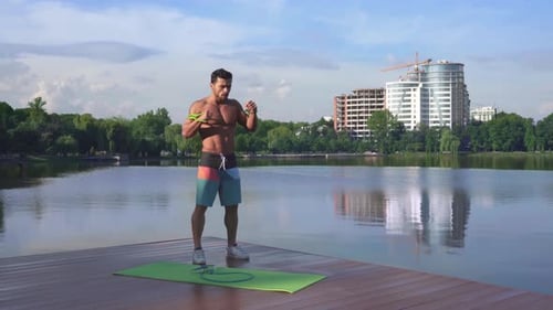 Muscular Man with Naked Torso Training Near City Lake