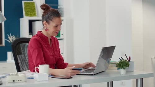 Office Worker Making Payment with Credit Card on Laptop