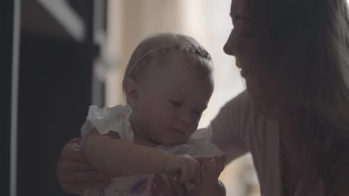 Close-up Portrait Young Woman Playing with Her Adorable Smiling Baby Girl at Home. Concept of a