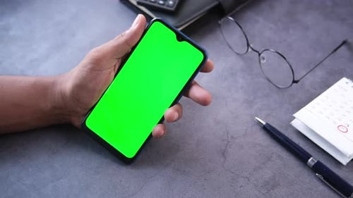 Rear View of Young Man Hand Using Smart Phone with Green Screen