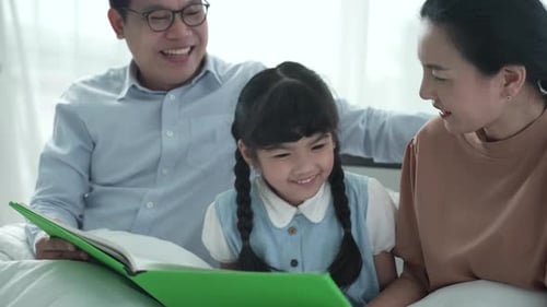 Father and mother are teaching their daughter homework at home, cosy family and education concept