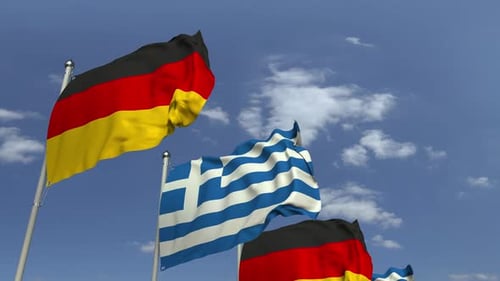 Waving Flags of Greece and Germany Against Blue Sky