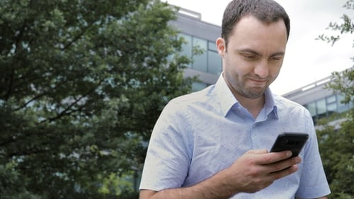 Caucasian businessman use of mobile phone in city.