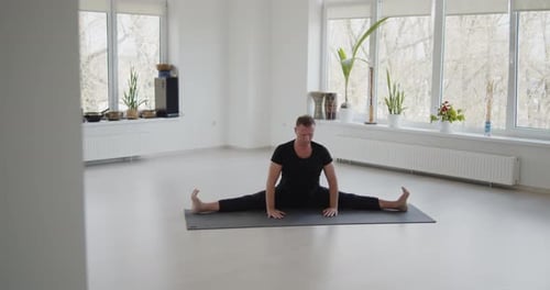 Man Stretching for Yoga in Bright Room