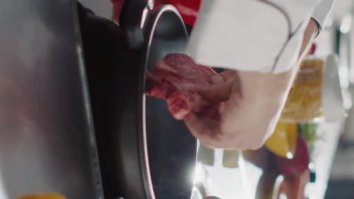 Chef Cooking Meat in Steaming Pan in Kitchen