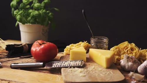Shredded Cheese with Fresh Basil and Italian Spaghetti on Wooden Kitchen Table