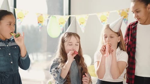 Children Blowing Party Favors at Birthday Party