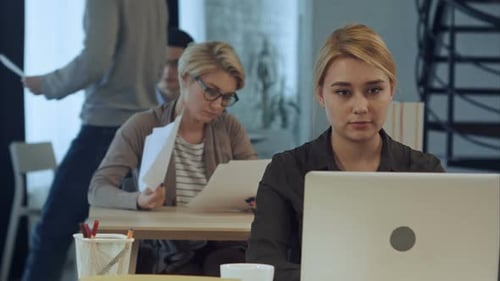 Young Woman Working on Laptop in the Modern Office