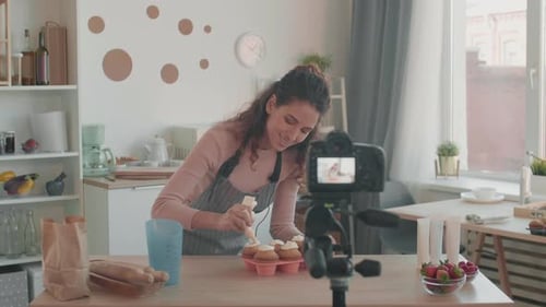 Woman Icing Cupcakes on Camera in Kitchen