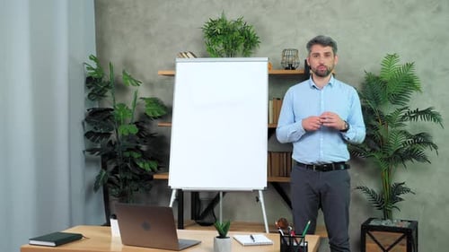 Professional Man Explaining Business Concepts at Whiteboard