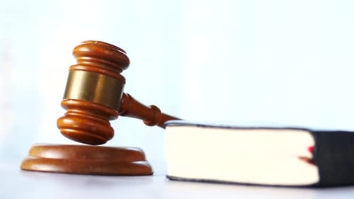 Wooden Gavel and Law Book on Table