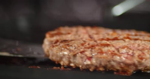 The Burger of Juicy Beef Is Fried in a Frying Pan.