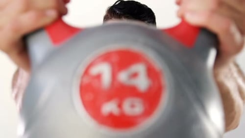 Muskulöser Mann hebt eine Kettlebell 4k