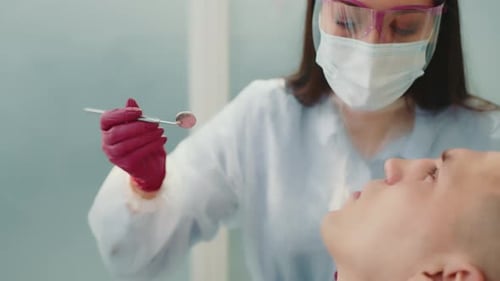 Dentist Examining Patient's Teeth in Clinic Close Up