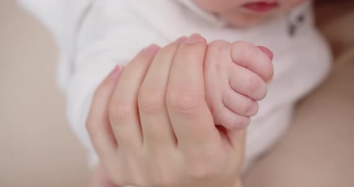 Mother Holds Tiny Foot of Infant