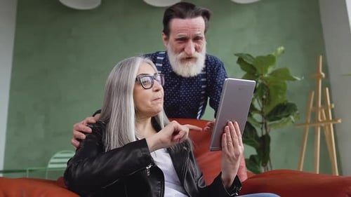 Senior Couple Waving During Tablet Video Call