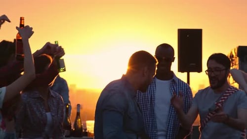 Friends Dancing on Rooftop Party at Sunset