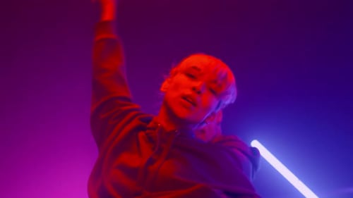 Young Adult Dancing with Neon Lighting