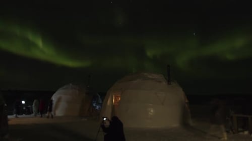 Tourists on the Platform About Igloo are Filming the Northern Lights in the Night Sky with Their